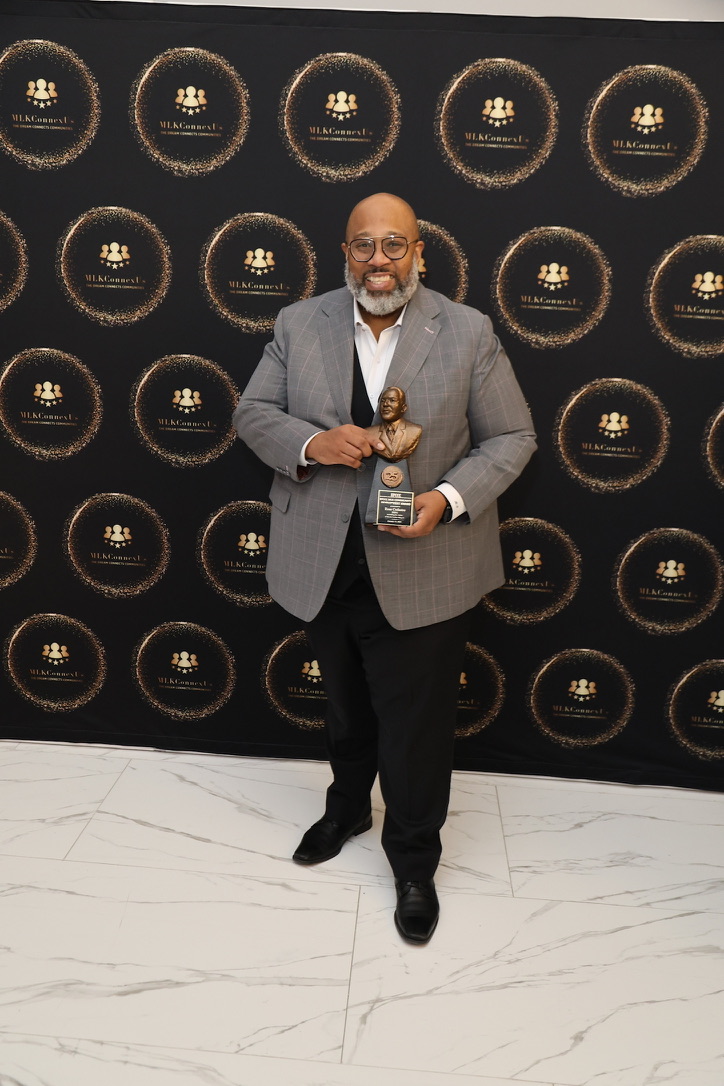 Ross holding an MLK ConnexUs award